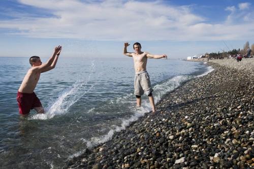Rapazes se refrescam do calor em Sochi na praia / Foto: Picture EPA
